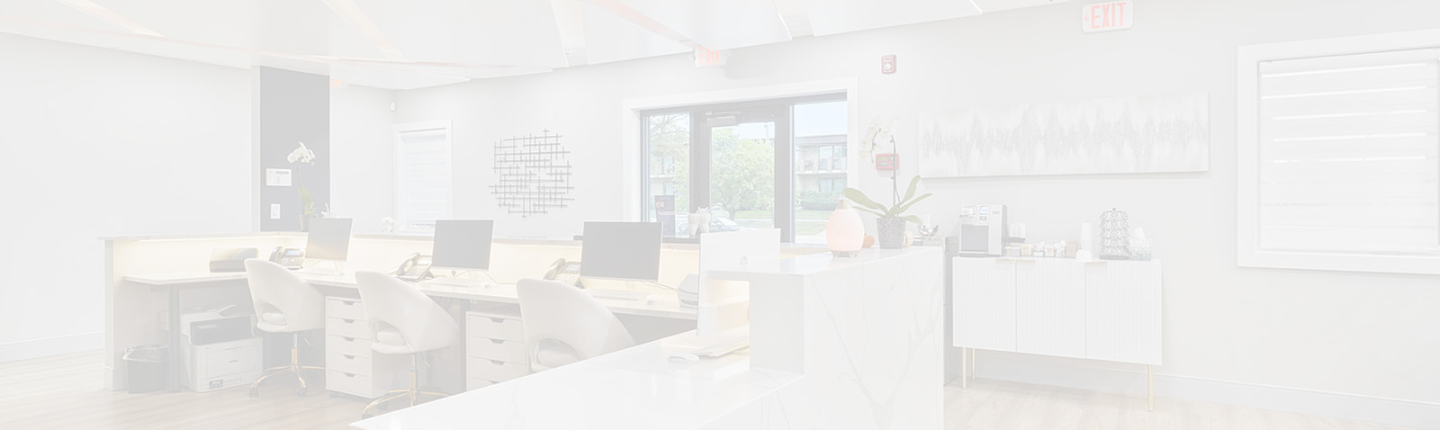 The image shows an interior view of a modern office space with a large open floor plan, featuring a reception area, meeting rooms, and individual workstations.